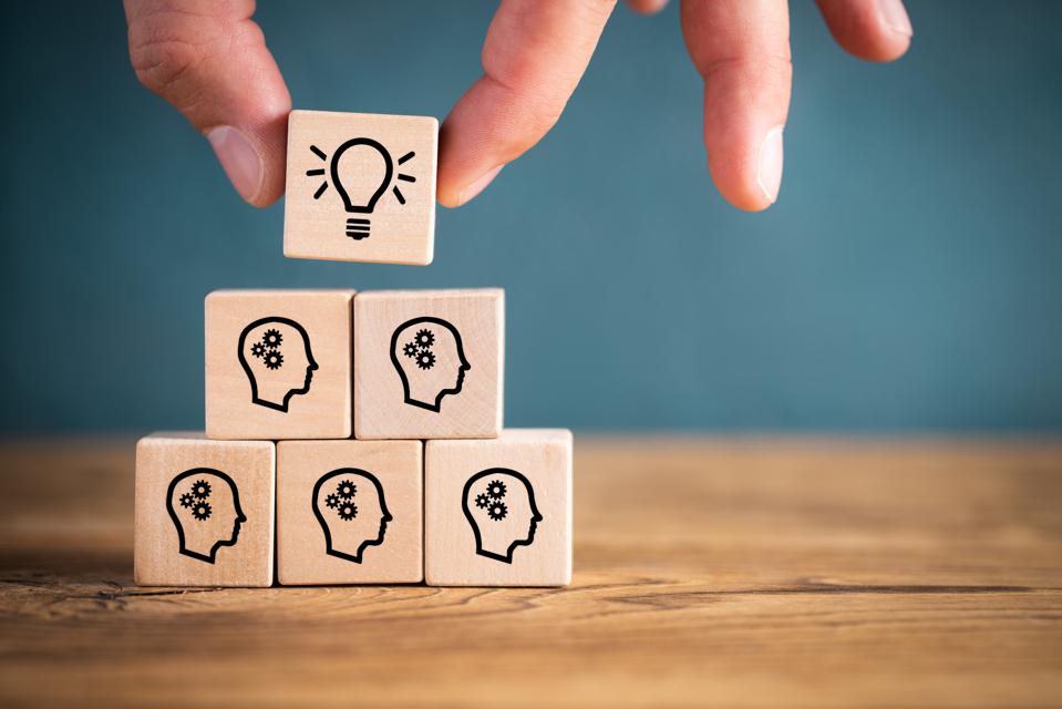 many people together having an idea symbolized by icons on cubes. employee experience